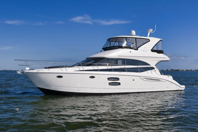 Slide: The Image of 2012 Meridian 441 Sedan yacht cruising on open water under clear blue skies. - 4