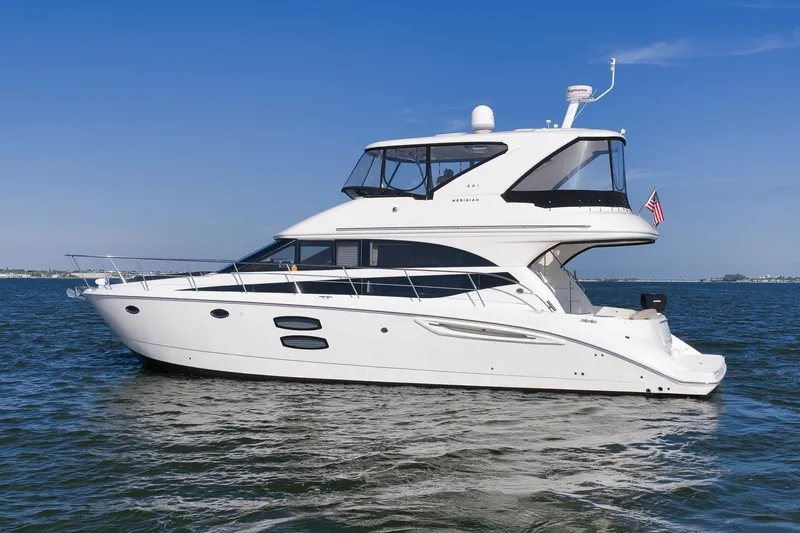 Slide: The Image of 2012 Meridian 441 Sedan yacht cruising on open water under clear blue skies. - 9