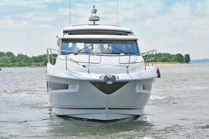 Slide: The Image of 2019 Prestige 460 yacht cruising on a calm waterway with lush greenery. - 2