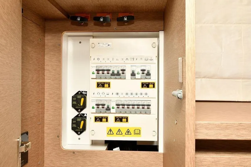 Slide: The Image of Electrical panel inside a 2019 Prestige 460 yacht, featuring circuit breakers and safety switches. - 26