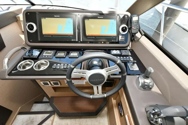 Slide: The Image of Cockpit of 2019 Prestige 460 yacht with dual navigation screens and steering wheel. - 29