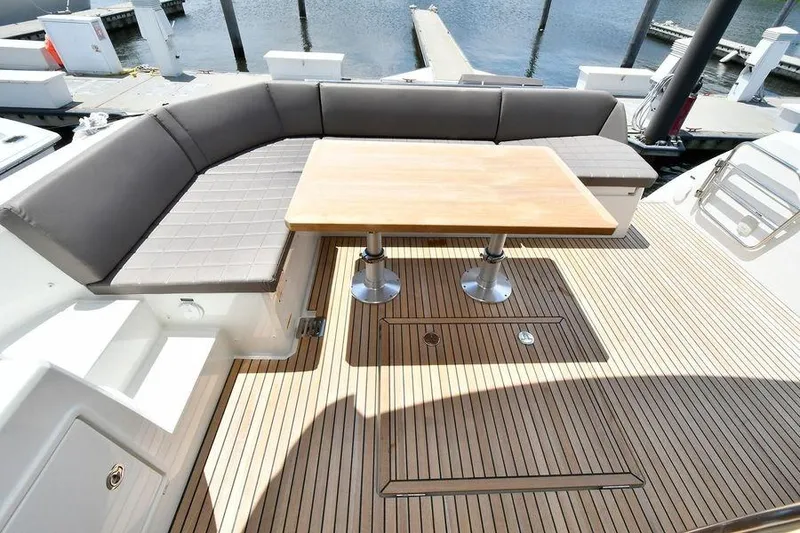 Slide: The Image of Luxurious 2019 Prestige 460 yacht deck with seating and wooden table. - 32