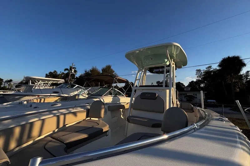 Slide: The Image of 2021 Key West 239 FS boat under clear blue sky, showcasing seating and helm. - 10