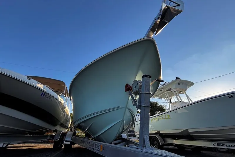 Slide: The Image of 2021 Key West 239 FS boat on trailer, parked between two other boats. - 8