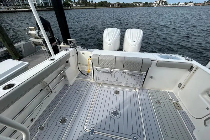 Slide: The Image of 2023 Pursuit S 288 Sport boat interior with dual engines, docked by the water. - 15