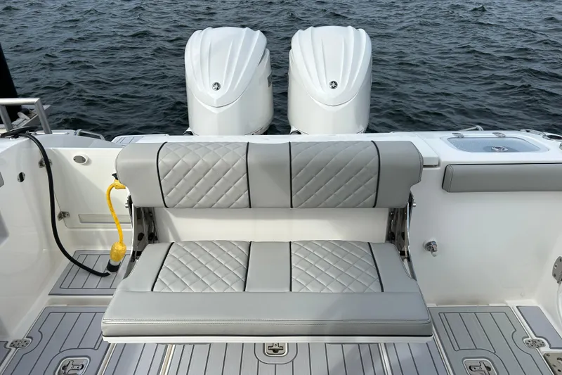 Slide: The Image of 2023 Pursuit S 288 Sport boat with dual engines and cushioned seating on the water. - 21