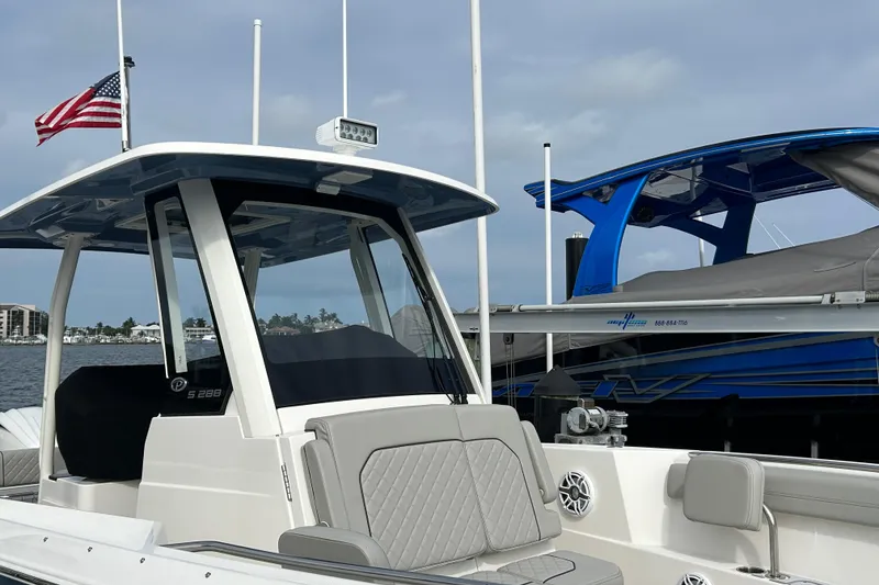 Slide: The Image of 2023 Pursuit S 288 Sport boat docked, featuring sleek design and American flag. - 3
