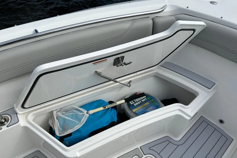 Slide: The Image of 2023 Pursuit S 288 Sport boat storage compartment with fishing gear and net. - 43