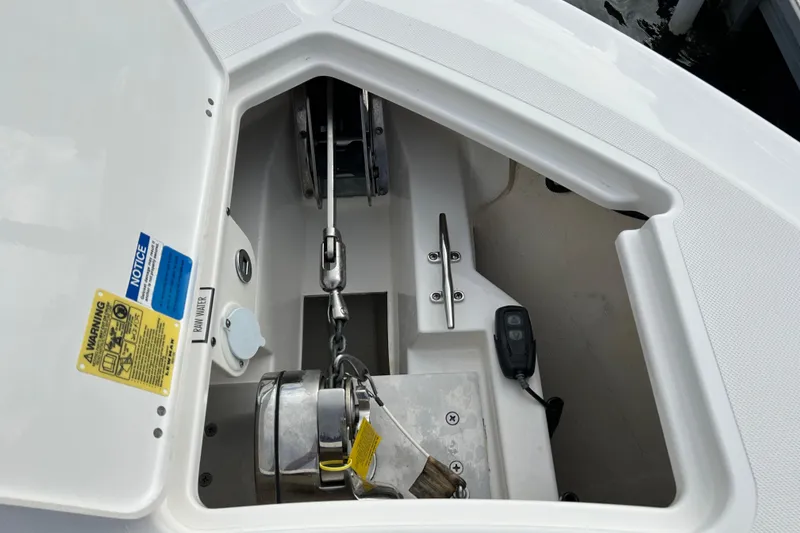 Slide: The Image of Anchor compartment of 2023 Pursuit S 288 Sport boat, featuring chain and winch. - 44