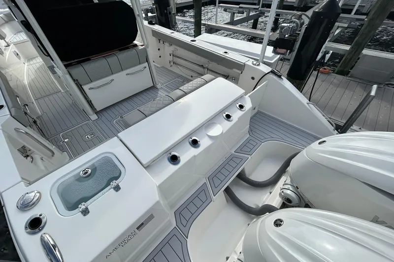 Slide: The Image of 2023 Pursuit S 288 Sport boat interior with seating and dual engines at dock. - 9
