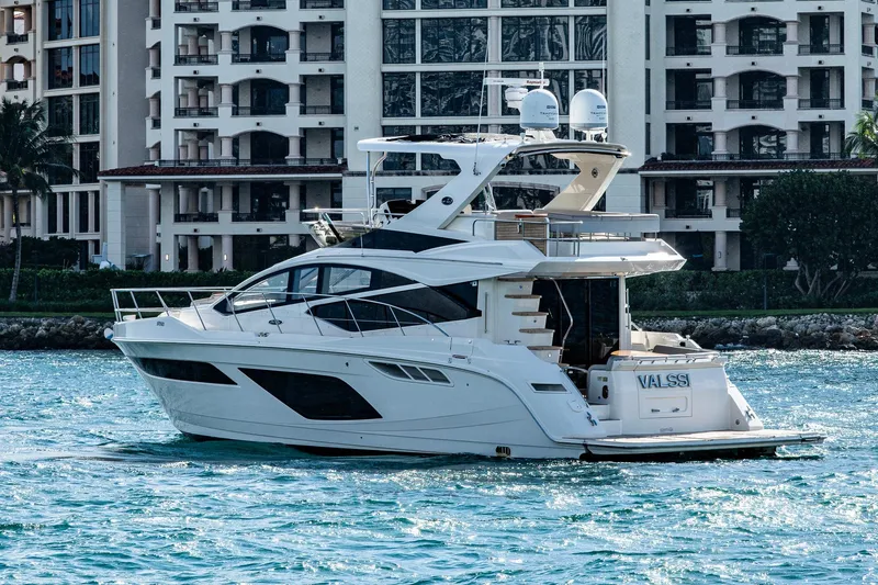 Slide: The Image of 2018 Sea Ray L550 Fly yacht cruising near luxury waterfront buildings. - 1
