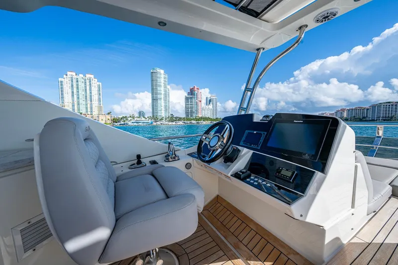 Slide: The Image of Helm of 2018 Sea Ray L550 Fly yacht with city skyline in background. - 10