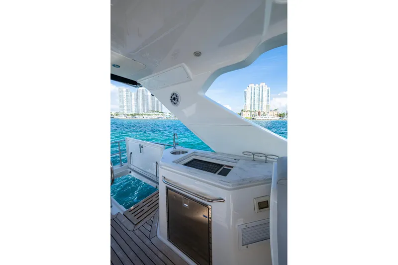 Slide: The Image of 2018 Sea Ray L550 Fly yacht deck with ocean view and city skyline. - 17