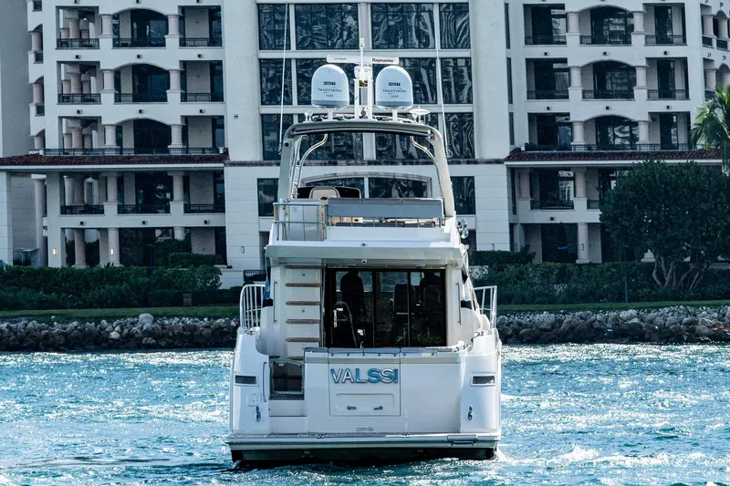 Slide: The Image of 2018 Sea Ray L550 Fly yacht cruising near waterfront buildings. - 2