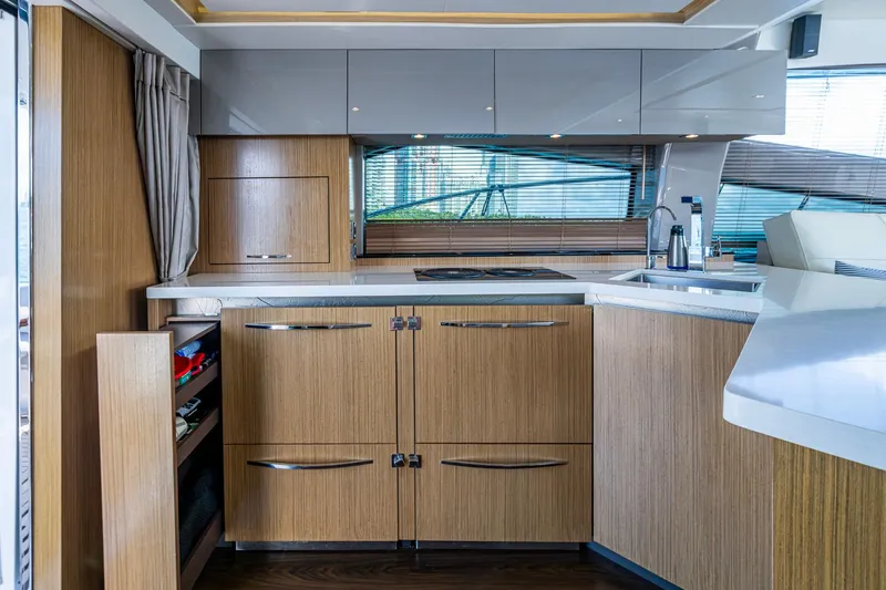 Slide: The Image of Luxurious 2018 Sea Ray L550 Fly yacht kitchen with modern wood cabinetry and sleek countertops. - 27
