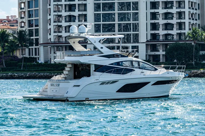 Slide: The Image of 2018 Sea Ray L550 Fly yacht cruising near luxury waterfront buildings. - 3