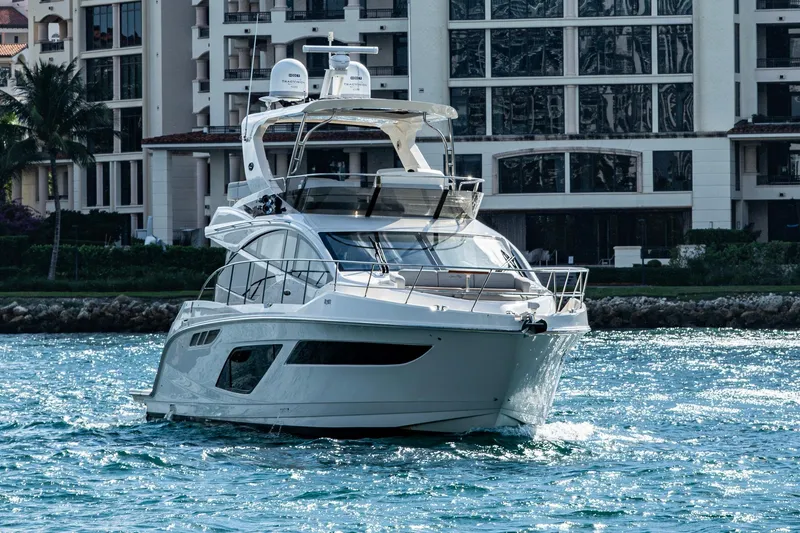 Slide: The Image of 2018 Sea Ray L550 Fly yacht cruising near waterfront buildings. - 4