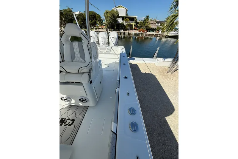 Slide: The Image of 2022 Contender 39 ST boat interior with seating, docked by waterfront homes. - 24