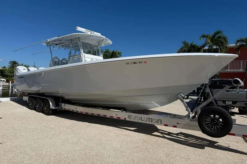 Slide: The Image of 2022 Contender 39 ST boat on trailer, parked outdoors under clear blue sky. - 3