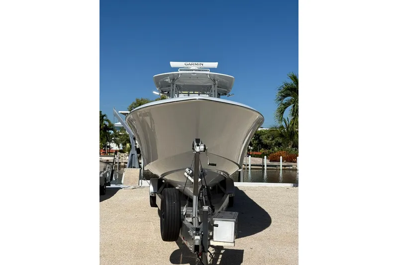 Slide: The Image of 2022 Contender 39 ST boat on trailer, parked near waterfront under clear blue sky. - 6