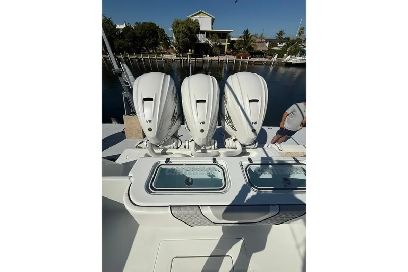 Slide: The Image of 2022 Contender 39 ST boat with triple V8 engines docked by the water. - 9