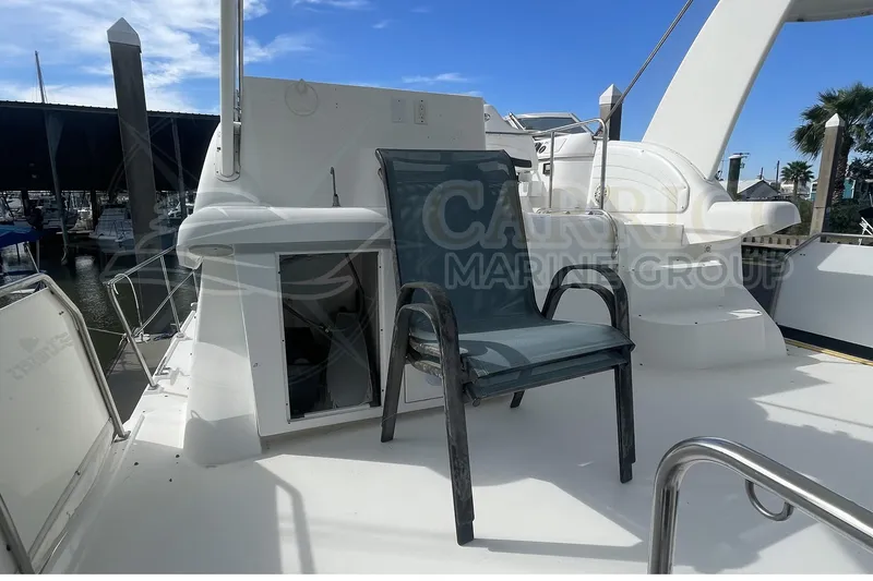 Slide: The Image of 1996 Cruisers Yachts 3650 Aft Cabin deck with chair, marina view. - 12