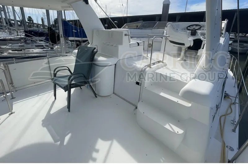 Slide: The Image of 1996 Cruisers Yachts 3650 Aft Cabin deck with seating and helm, docked at marina. - 14