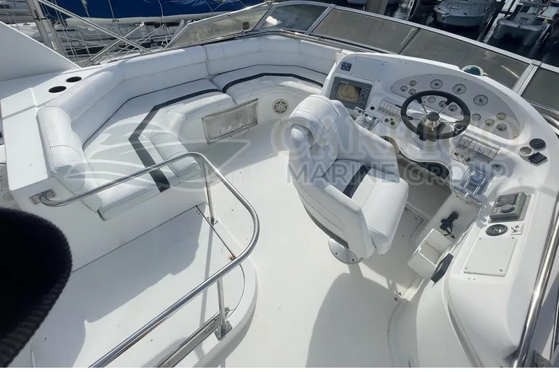 Slide: The Image of 1996 Cruisers Yachts 3650 Aft Cabin helm with white seating and control panel. - 17