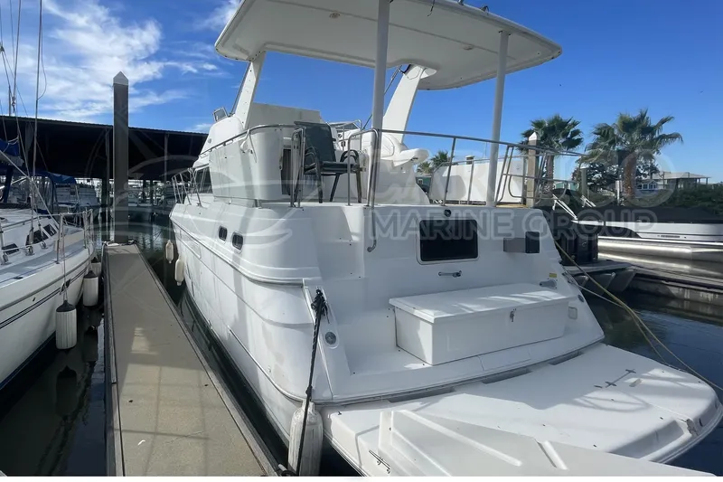 Slide: The Image of 1996 Cruisers Yachts 3650 Aft Cabin docked at marina under clear blue sky. - 4
