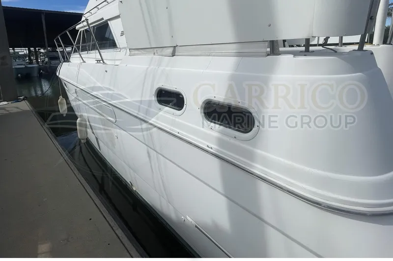 Slide: The Image of 1996 Cruisers Yachts 3650 Aft Cabin docked, showcasing sleek white exterior design. - 5