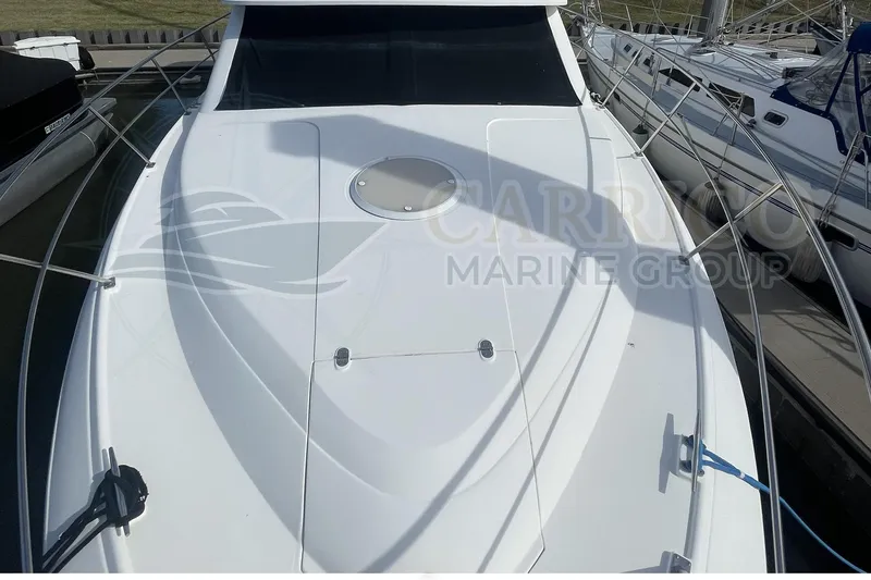 Slide: The Image of 1996 Cruisers Yachts 3650 Aft Cabin boat docked, showcasing sleek white deck design. - 7