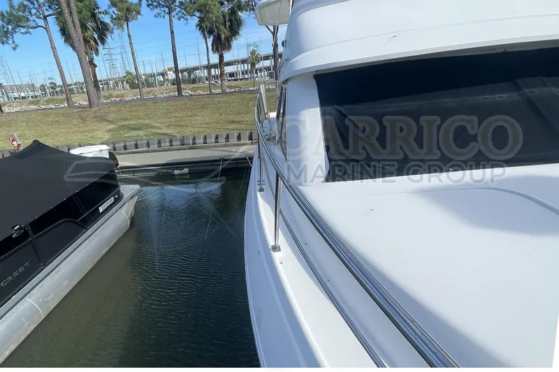 Slide: The Image of 1996 Cruisers Yachts 3650 Aft Cabin docked near a covered boat. - 9