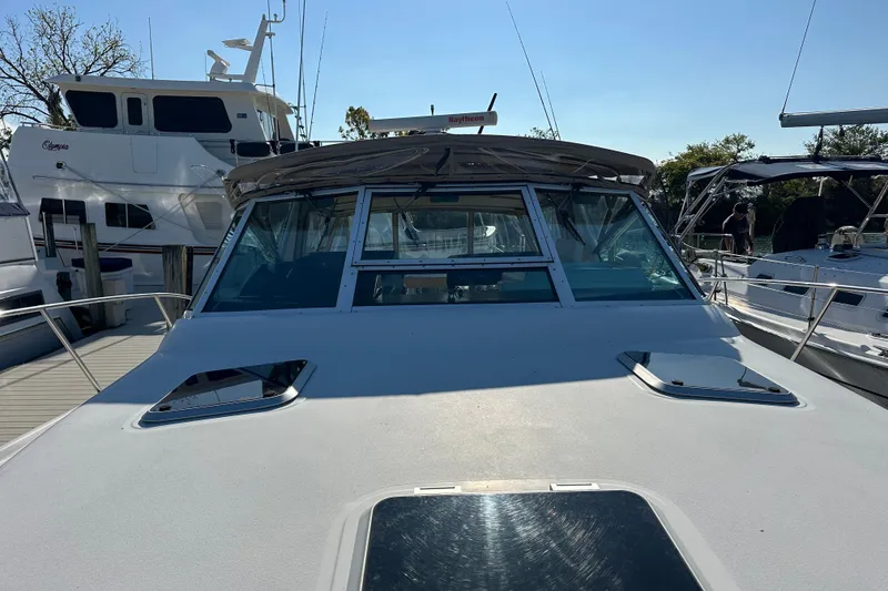 Slide: The Image of 2001 Tiara Yachts 3500 Open docked, featuring a beige canopy and sleek design. - 10