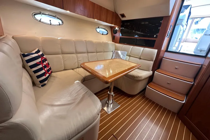 Slide: The Image of 2001 Tiara Yachts 3500 Open interior with plush seating and wooden table. - 23