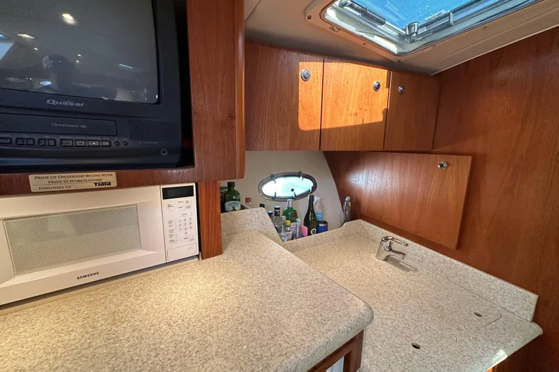 Slide: The Image of Interior of 2001 Tiara Yachts 3500 Open with plush seating and wooden accents. - 24