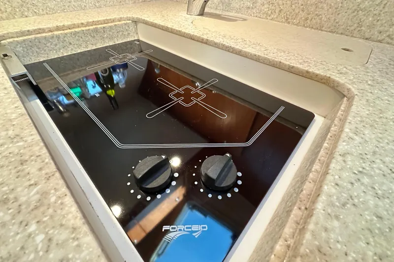 Slide: The Image of 2001 Tiara Yachts 3500 Open interior with kitchenette, TV, and storage cabinets. - 25