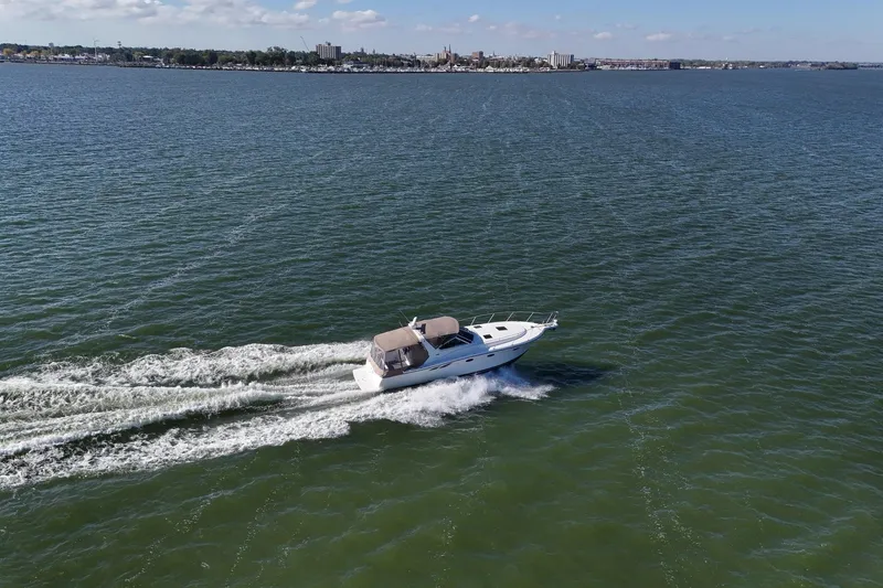 Slide: The Image of 2001 Tiara Yachts 3500 Open cruising on a vast, calm sea under a clear sky. - 30
