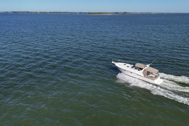 Slide: The Image of 2001 Tiara Yachts 3500 Open cruising on a sunny day with amusement park in background. - 34