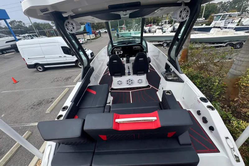 Slide: The Image of 2025 Monterey Elite 27 OB boat interior with modern seating and dashboard in a marina setting. - 15