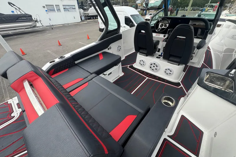Slide: The Image of 2025 Monterey Elite 27 OB boat interior with sleek black and red seating, modern dashboard. - 16