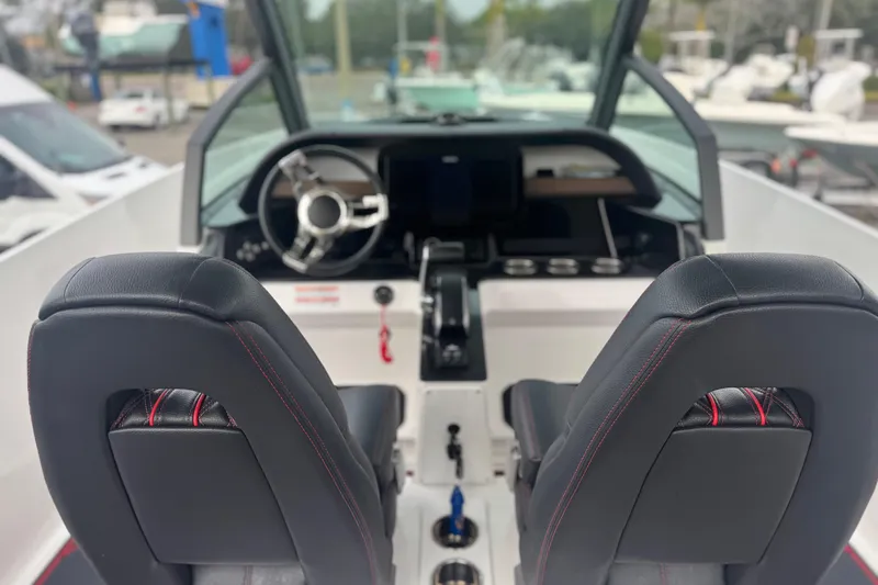 Slide: The Image of 2025 Monterey Elite 27 OB boat interior with steering wheel and dual seats. - 21