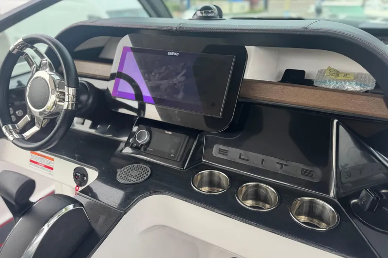 Slide: The Image of 2025 Monterey Elite 27 OB dashboard with steering wheel, touchscreen, and cup holders. - 22