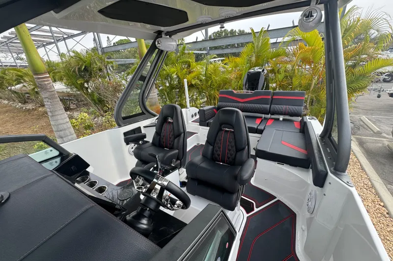Slide: The Image of 2025 Monterey Elite 27 OB boat interior with sleek black and red seating. - 32