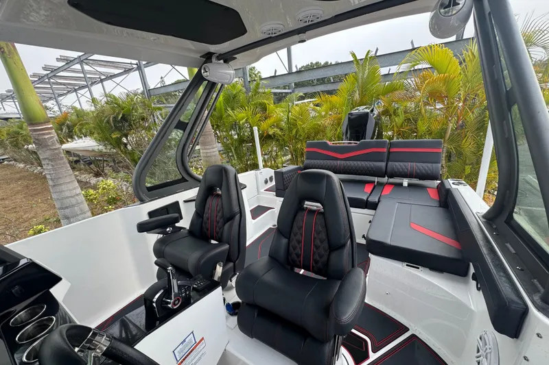 Slide: The Image of 2025 Monterey Elite 27 OB boat interior with black and red seating, modern design. - 33