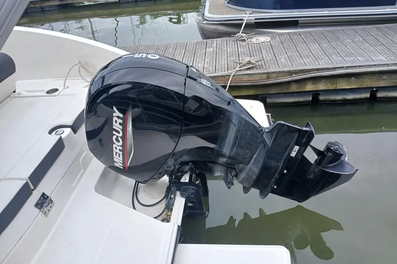 Slide: The Image of 2023 Bayliner DX 2200 with Mercury outboard motor docked at marina. - 13