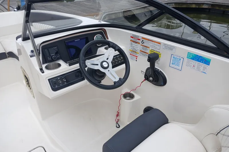Slide: The Image of 2023 Bayliner DX 2200 boat cockpit with steering wheel and control panel. - 8