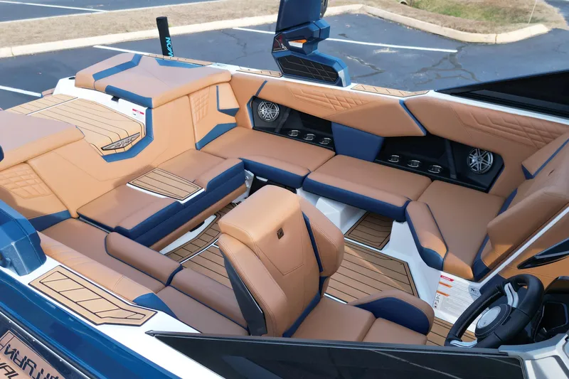 Slide: The Image of 2024 Nautique Super Air Nautique S21 interior with tan and blue seating, premium design. - 10