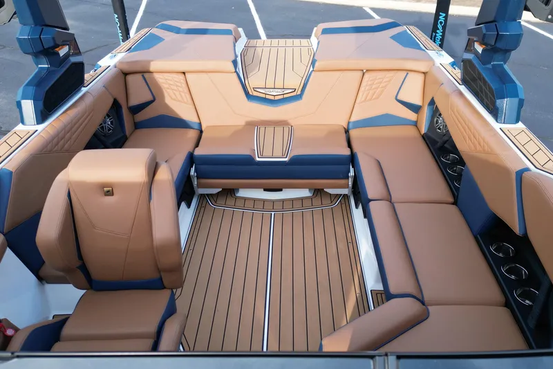 Slide: The Image of 2024 Nautique Super Air Nautique S21 interior with tan and blue seating, luxurious design. - 12