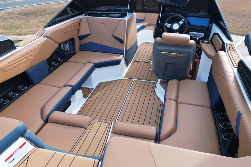 Slide: The Image of 2024 Nautique Super Air Nautique S21 interior with tan and blue seating, sleek design. - 15