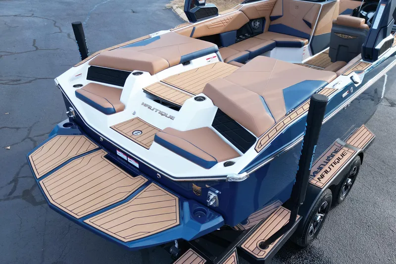 Slide: The Image of 2024 Nautique Super Air Nautique S21 boat with tan and blue seating, rear view. - 16